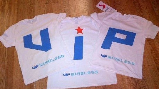 Three white tees show blue letterforms with red accents. The photograph records the different designs together; the specific project name is not documented.