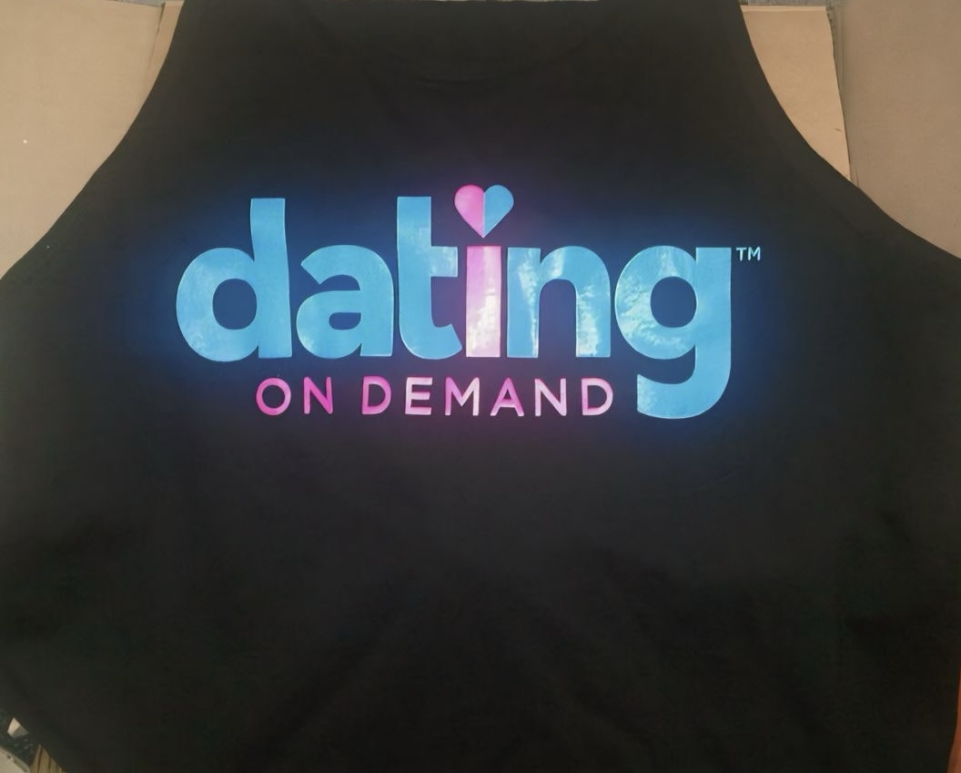 A black garment carries a blue-to-pink “dating on demand” wordmark with a small heart detail.